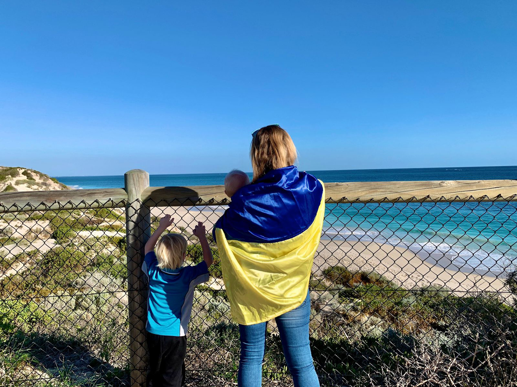 family looking over beach with Ukraine flag